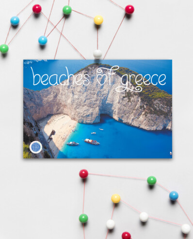 Postcard of Greek beach on a wall with colorful pins.