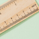 Wooden ruler on a green background.